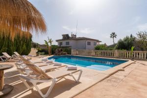 een rij ligstoelen naast een zwembad bij Villa Sayana in Palma de Mallorca