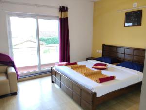a bedroom with a large bed with a large window at Forest Gate in Ooty