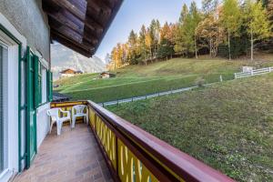 a balcony with a table and a view of a field at Ciasa Tach in Pozza di Fassa