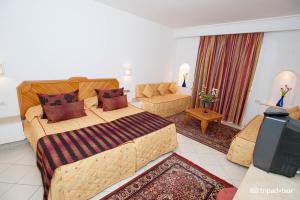 a hotel room with a bed and a couch at Hotel Golf Residence in Hammam Sousse
