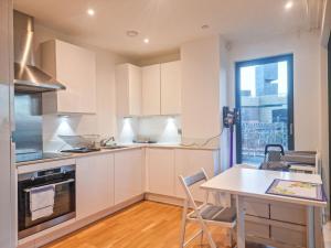 een keuken met witte kasten en een tafel en een raam bij Pass the Keys The perfect stay in Londen