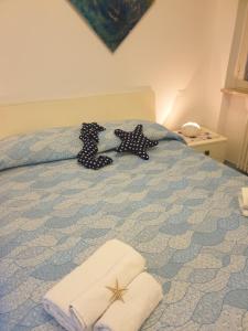 1 dormitorio con 1 cama con toallas en SOGNO BLU suite, en Gaeta