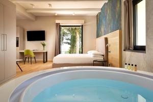 bagno con vasca in una camera d'albergo di Borgobrufa Spa Resort Adults Only a Brufa