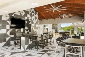 a patio with tables and chairs and a fireplace at The Nines Scottsdale in Scottsdale
