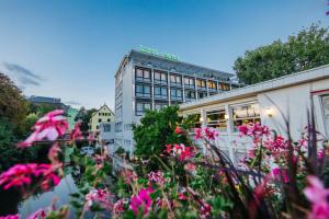 un edificio con flores rosas delante de él en Insel-Hotel Heilbronn, en Heilbronn