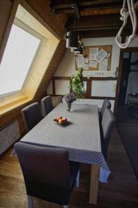 uma mesa de jantar com cadeiras e um vaso de flores em Haus Fichtelgebirge em Nagel