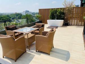 a balcony with a table and chairs and a bath tub at Parc Borough City Resort in Chiang Mai
