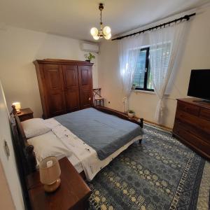 um quarto com uma cama, uma mesa e uma televisão em Studio apartman em Meljine