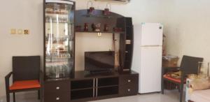a entertainment center with a television and a refrigerator at Family Environmental Studio/مجلس خارجي بفيلا سكنية 