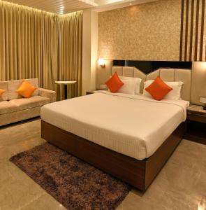 a bedroom with a large bed and a couch at Brio Hotel in Kolkata