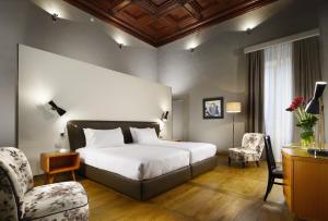 Habitación de hotel con cama y silla en Hotel Garibaldi Blu - WTB Hotels, en Florencia
