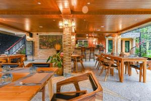 un restaurante con mesas y sillas de madera en Cascade Tara en Na Mueang