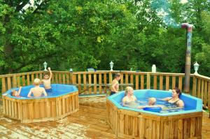 a group of children in hot tubs on a deck at Landhouse in Olofström