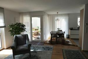 a living room with a table and a chair at BioTop Appartement Kronplatz in Perca