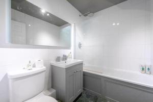 a bathroom with a toilet and a sink and a tub at Spacious 2 Bedroom Flat in Wandsworth in London