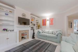 a living room with a couch and a fireplace at Spacious 2 Bedroom Flat in Wandsworth in London