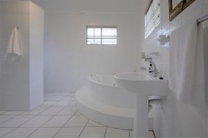 uma casa de banho branca com um lavatório e um WC em #9 Notties Avenue em Nottingham Road
