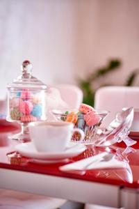 a table with a plate of candy and a cup of coffee at Appartamento a uso turistico in Viterbo