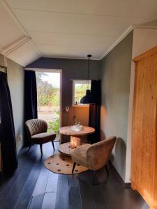 uma sala de estar com uma mesa e cadeiras e uma janela em De Schotse Hooglander em Smilde