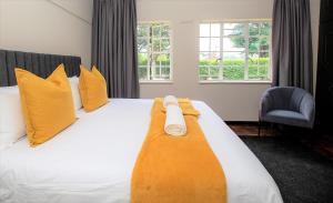 a hotel room with a bed with yellow pillows at #9 Notties Avenue in Nottingham Road