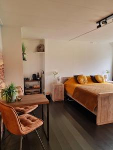 ein Schlafzimmer mit einem Bett, einem Holztisch und einem Tisch in der Unterkunft De Schotse Hooglander in Smilde