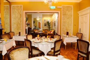 une salle à manger avec des tables et des chaises blanches dans l'établissement Kilronan House, à Dublin