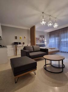 uma sala de estar com um sofá e uma mesa em Center Point Thessaloniki em Tessalónica