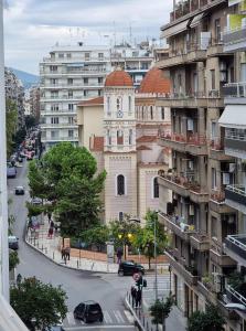 um edifício com uma torre de relógio no meio de uma cidade em Center Point Thessaloniki em Tessalônica