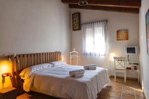 a bedroom with a bed with two towels on it at Vinarius, Posada Rural in Castellanos de Villiquera