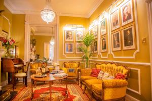 uma sala de estar com mobiliário amarelo e quadros nas paredes em Kilronan House em Dublin