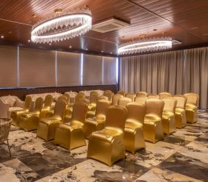 a conference room with gold chairs and a stage at Brio Hotel in Kolkata