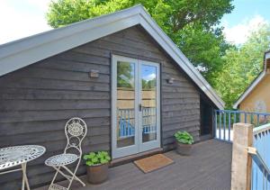 a small cabin with a table and a chair on a deck at The Carters Loft in Badingham