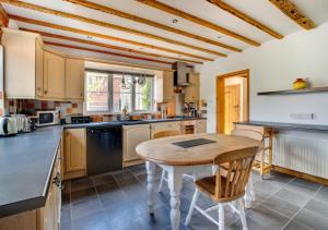 a kitchen with a wooden table in the middle at 2 Benhall Green in Saxmundham