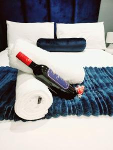 a bottle of wine laying on a bed with towels at Sugar Shores - Studio Apartment in Sibaya