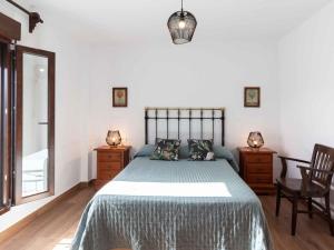 a bedroom with a large bed and two chairs at Casa de Las Granadas in Nigüelas