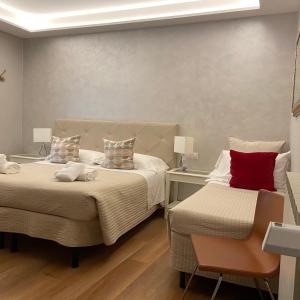 a bedroom with two beds and a chair in it at Soggiorno Alessandra in Florence