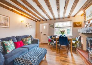 a living room with a couch and a table at Puddingmoor Cottage in Beccles