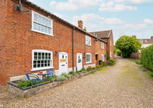 una casa de ladrillo con una mesa delante en Puddingmoor Cottage en Beccles