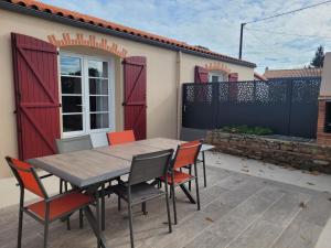a table and chairs on a patio with a house at chambre d'hôte chez Mimidid in Le Landreau