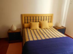 1 dormitorio con 1 cama con sábanas azules y almohadas amarillas en Casa de Campo 1, en Lavre