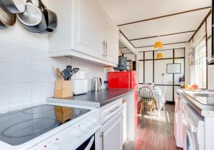 a kitchen with white cabinets and a red refrigerator at Beach House in Southwold