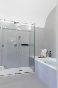 a glass shower in a bathroom with a tub at Peonia Boutique Apartments in Palermo