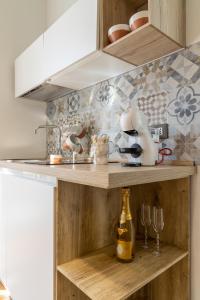 a kitchen with a wooden shelf with a bottle and glasses at Peonia Boutique Apartments in Palermo