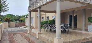 a patio with chairs and a table in a building at Crayfish Creek Guest House in Richards Bay