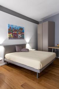 a bedroom with a bed and a painting on the wall at Peonia Boutique Apartments in Palermo +56 photos