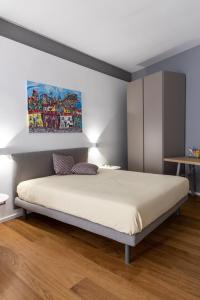 パレルモにあるPeonia Boutique Apartmentsのベッドルーム1室(ベッド1台付)が備わります。壁には絵画が飾られています。