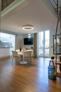 un salon avec une table et des chaises et une cuisine dans l'établissement Peonia Boutique Apartments, à Palerme