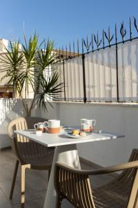a table with a plate of food on a balcony at Peonia Boutique Apartments in Palermo