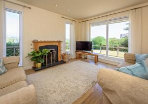 a living room with a fireplace and a tv at Bryn in Abersoch