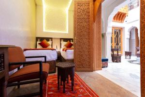 Palais Tara & Spa في مراكش: غرفة نوم بسريرين وطاولة في غرفة